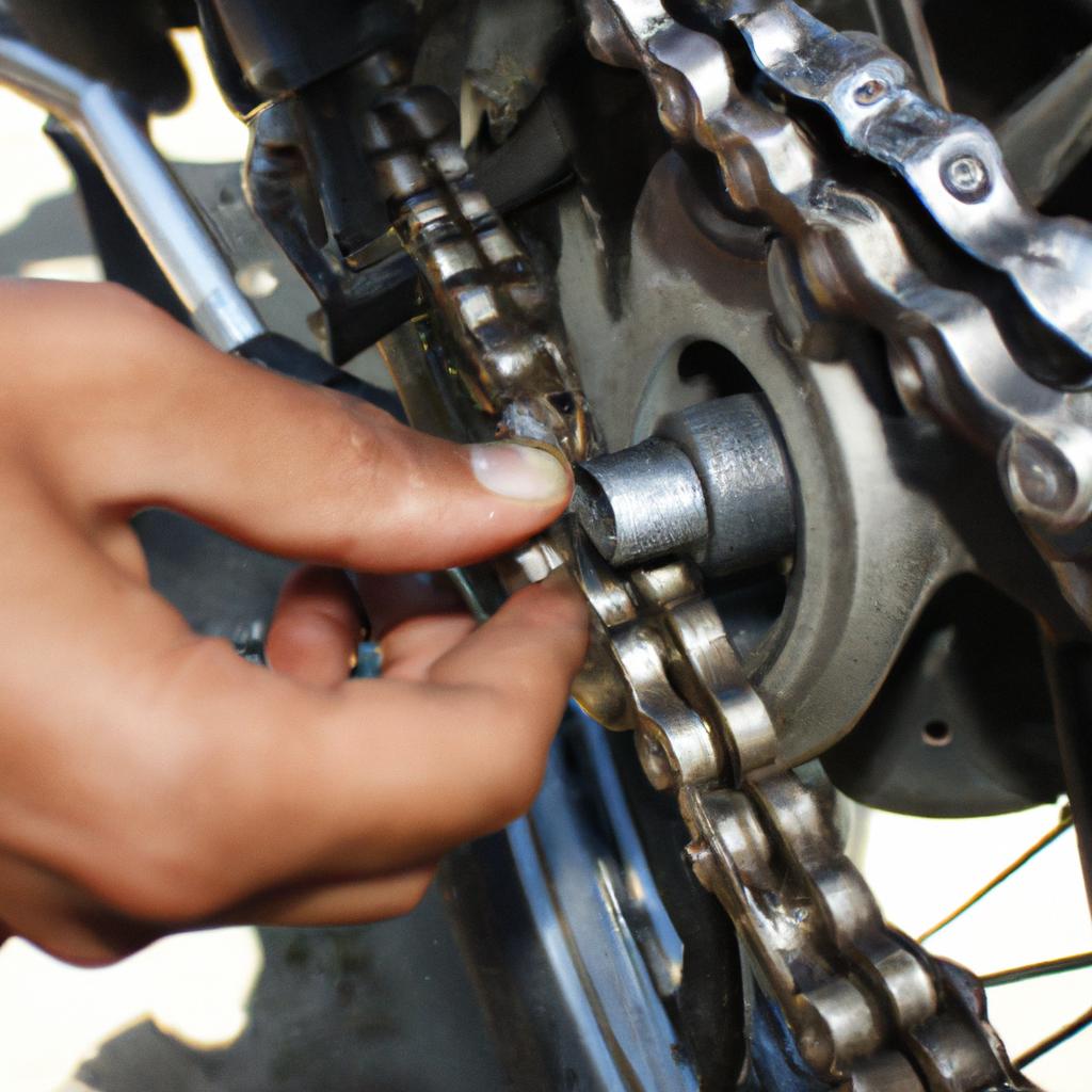 Person adjusting motorcycle chain tension